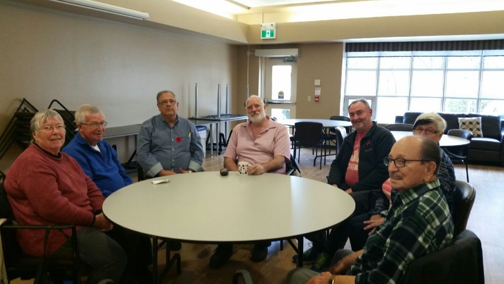 Social worker Paul Yost (pictured wearing a poppy) and Peter White (pictured to his left) at a Rural Support meeting.