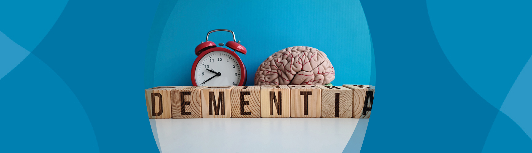 Wood blocks spelling out "dementia." Red alarm clock. Brain model.