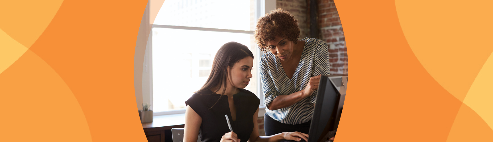 Younger woman is helped by her mentor.