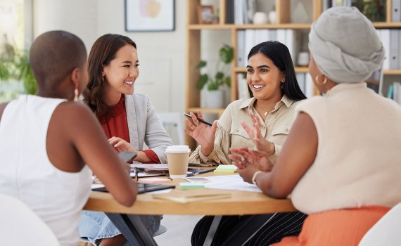A group of workers gathered around a table discussing ideas.