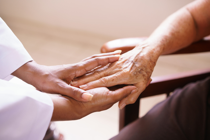 Caregiver holding the hand of patient