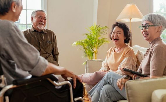A group of older adults are gathered together laughing.