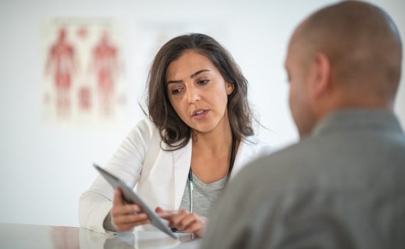 A point of care worker shows the results of a test to a patient