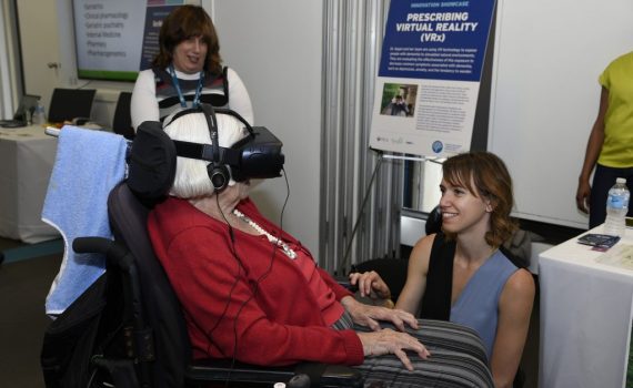 Lora Appel helps a senior use virtual reality