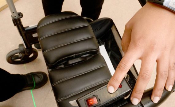 Person pressing a button on a walker using their finger