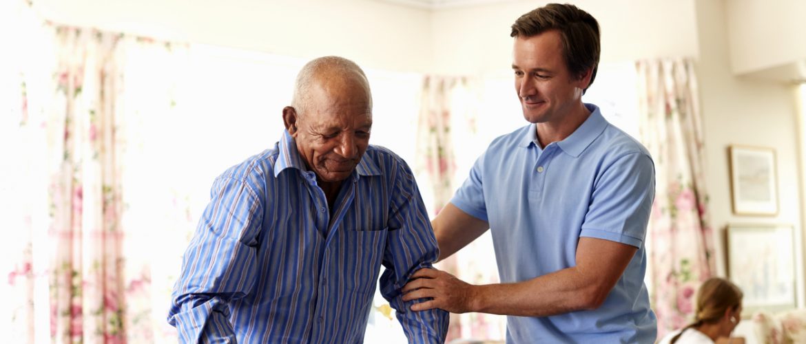 A young man helping an older adult with his walker