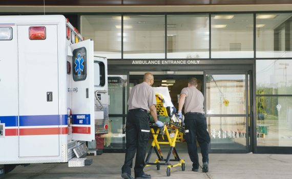 Paramedics taking patient on stretcher from ambulance to hospital