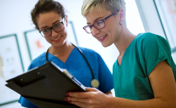 Two point-of-care workers checking a medication list