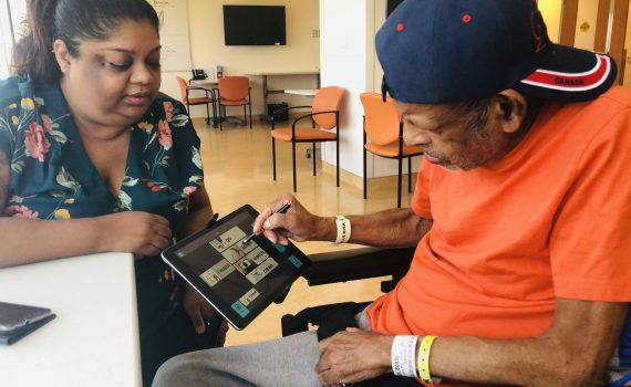 Older male adult uses the Linggo app with a family member