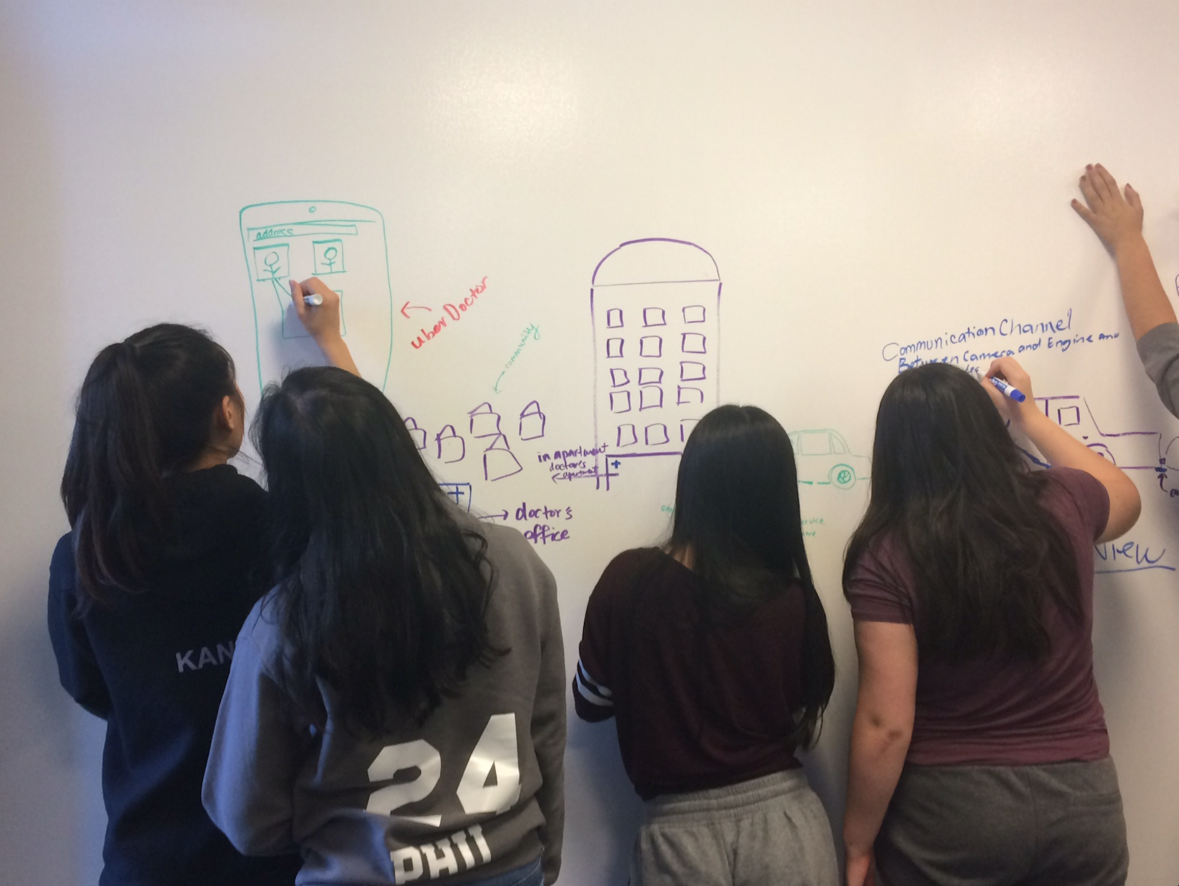 Students draw on the white board during a CABHI-hosted workshop to brainstorm innovations.