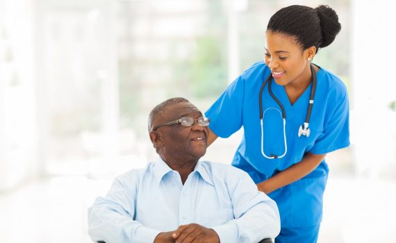 african nurse taking care of senior patient in wheelchair
