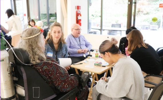 A group of seniors and students sitting around a table.