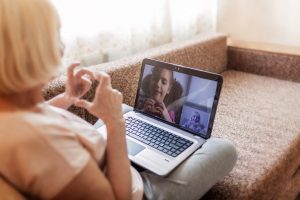 Older adult woman on a video conference call with a little girl.