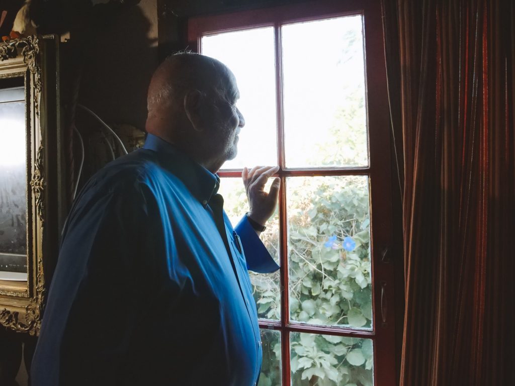 Older adult man looking out of the window