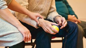 Caregiver holding hand of elderly person