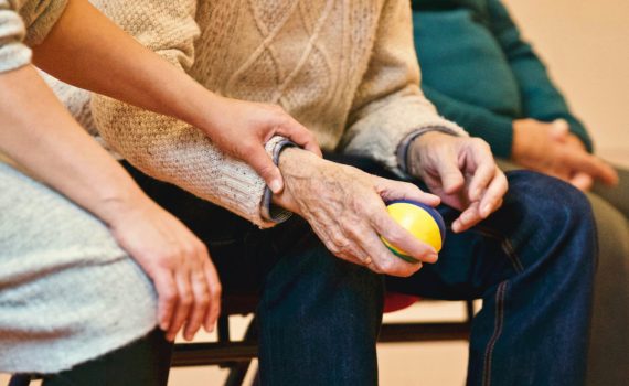 Caregiver holding hand of elderly person
