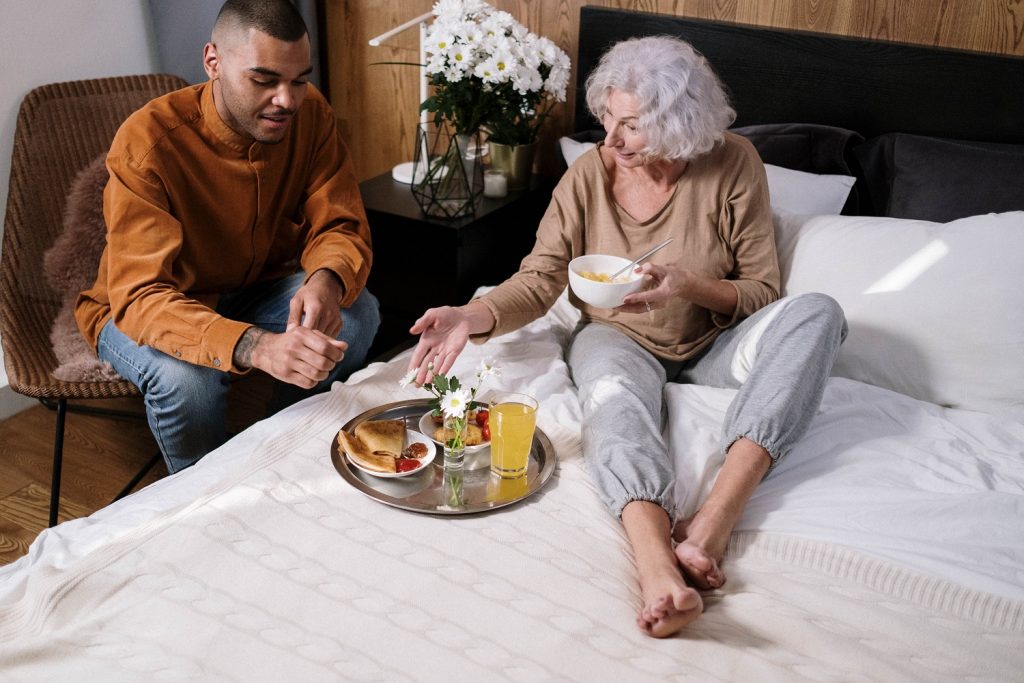 young male sitting next to elderly woman