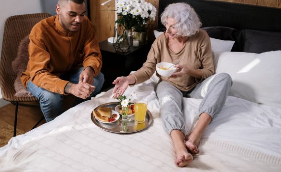 young male sitting next to elderly woman