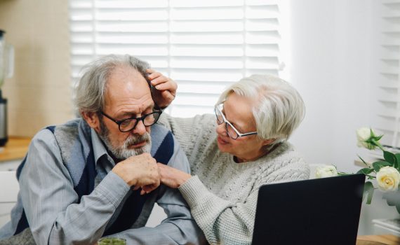 Woman touching the forehead of an older adult man