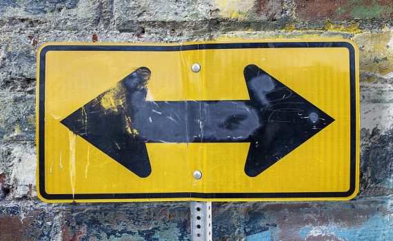 Road sign with arrows pointing in multiple directions