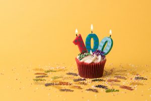 A cupcake with birthday candles spelling out 100.